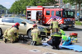 Fietser vast onder auto