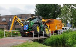 Tractor zakt door brug