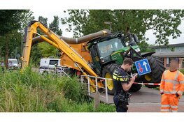 Tractor zakt door brug