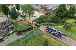 Tractor zakt door brug