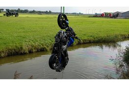 Motorrijder vliegt meters door de lucht en eindigt in het water na botsing met auto