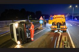 Bestelbus ramt betonblok en belandt op zijkant op N235
