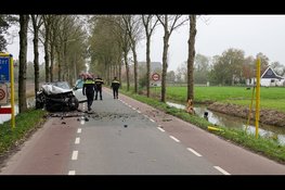 Auto raakt van de weg en ramt plaatsnaambord en boom